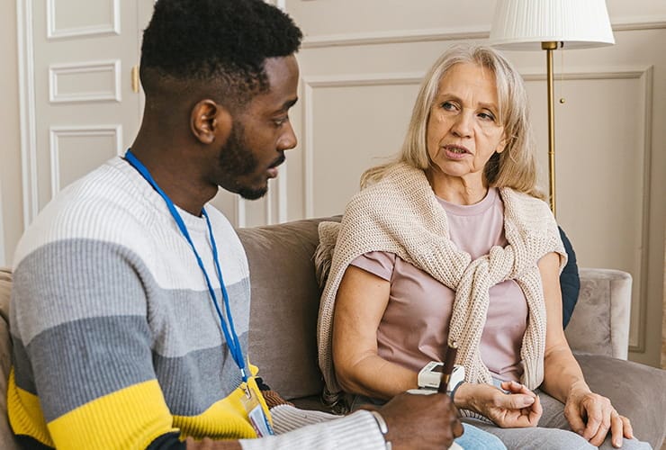 Two people speaking with eachother. One monitors the other's heart with a digital monitor