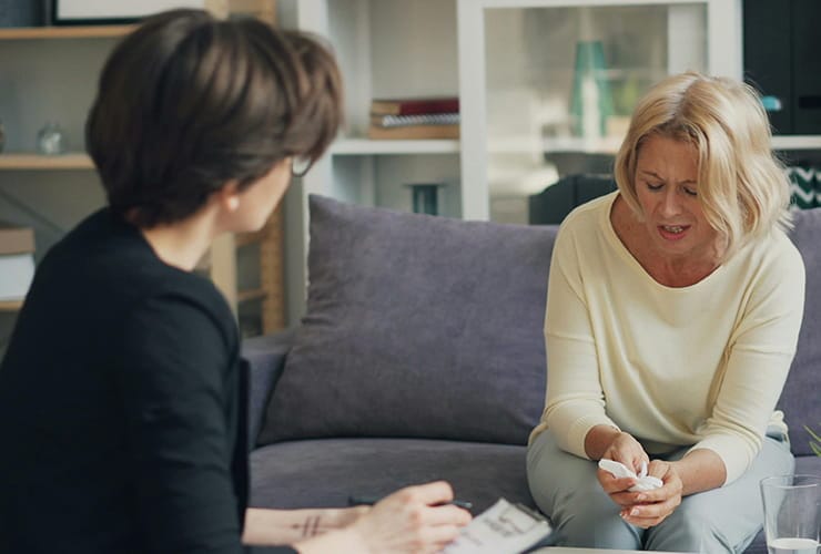 Sad woman speaking with therapist during a therapy session.