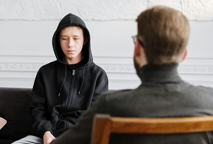 Teenager speaking with therapist during a session.