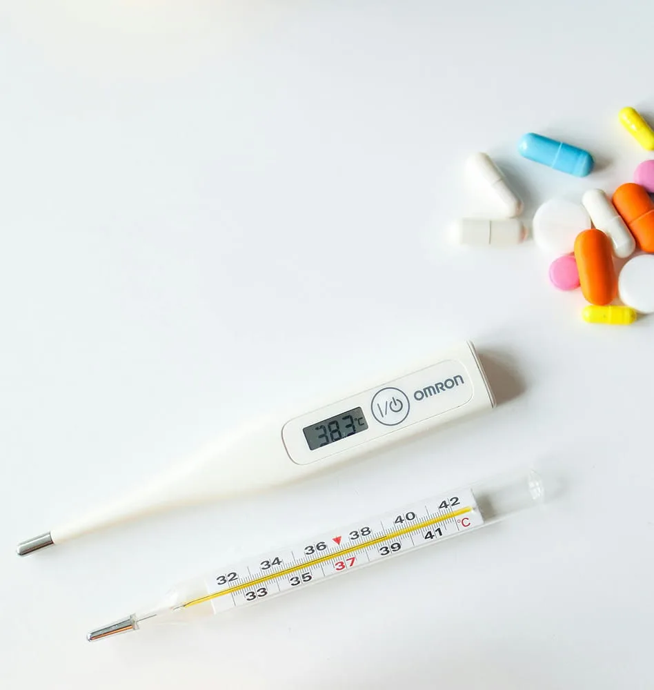 Image of a digital thermometer and group of medication